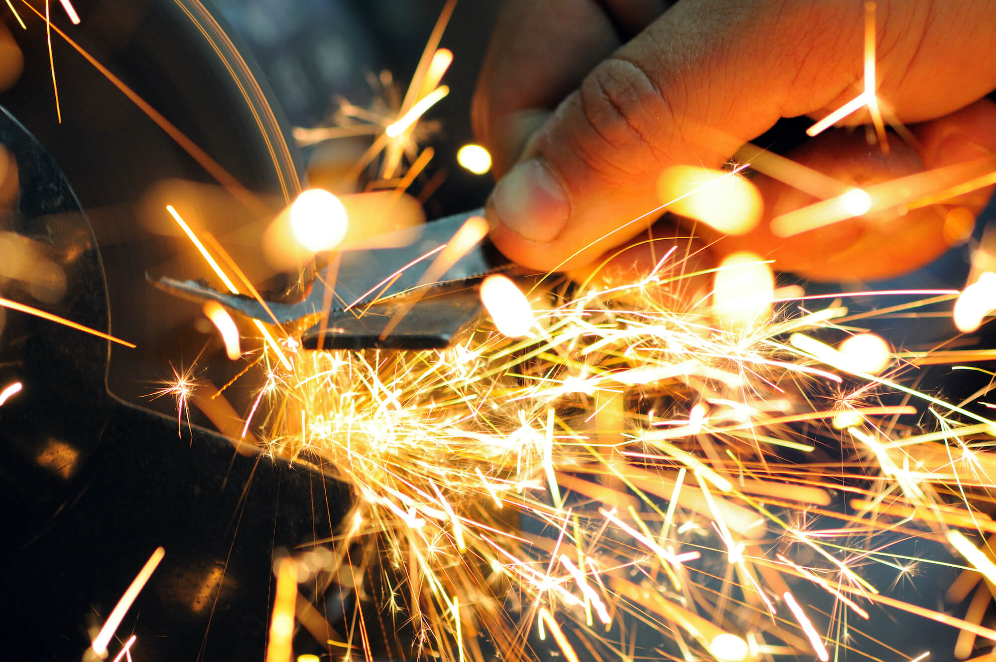 https://koutsilas.gr/wp-content/uploads/2021/02/man-holds-detail-hand-works-with-equipment-cutting-metal-bright-fiery-sparks-fly-apart-closeup-photo.jpg